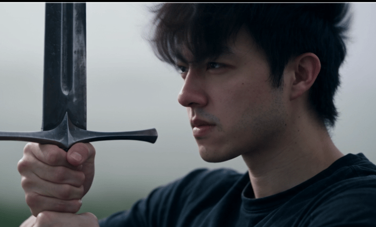 Side-profile reference of the protagonist in dark clothing holding an enormous steel greatsword